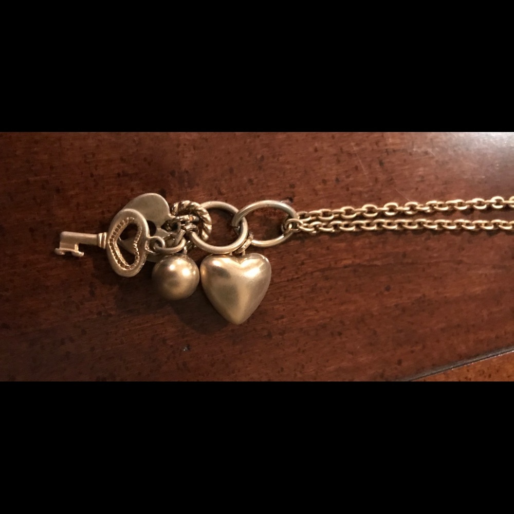 Gold tone necklace with charms of hearts and key